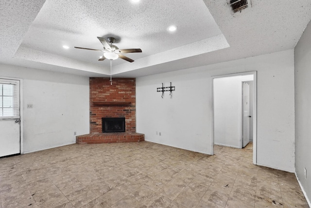 8512 Whitney Dr, White Settlement, TX 76108 - unfurnished living room with a tray ceiling, a ceiling fan, a brick fireplace, recessed lighting, and a textured ceiling