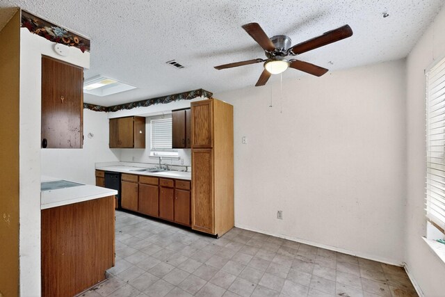 8512 Whitney Dr, White Settlement, TX 76108 - kitchen featuring light countertops, brown cabinets, ceiling fan, dishwasher, and a textured ceiling