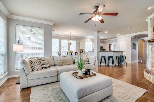 105 Cassandra Dr, Forney, TX 75126 - living room featuring arched walkways, crown molding, ceiling fan, baseboards, and wood finished floors
