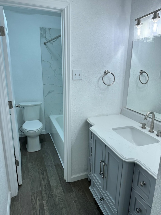 14800 Enterprise Dr Unit 17B, Farmers Branch, TX 75234 - bathroom featuring wood finished floors, vanity, toilet, shower / tub combination, and baseboards