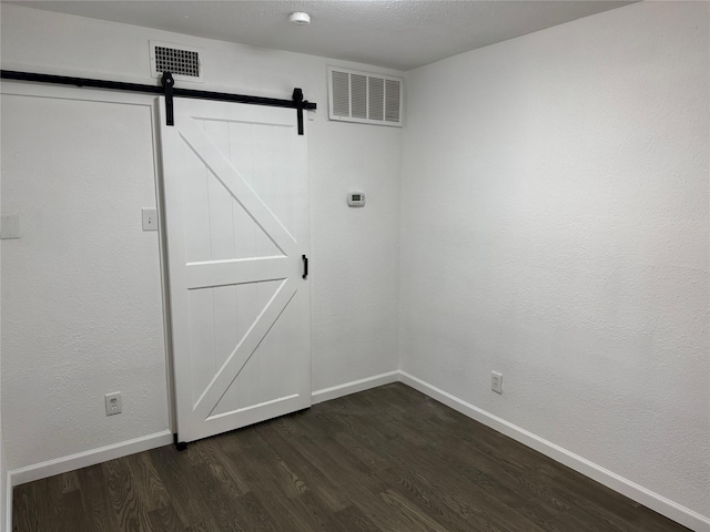 14800 Enterprise Dr Unit 17B, Farmers Branch, TX 75234 - laundry area with dark wood-type flooring, a barn door, and baseboards