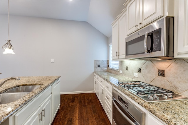 9728 Bitterroot Dr, Little Elm, TX 75068 - kitchen with stainless steel appliances, vaulted ceiling, dark wood finished floors, tasteful backsplash, and decorative light fixtures