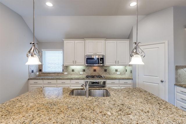 9728 Bitterroot Dr, Little Elm, TX 75068 - kitchen featuring appliances with stainless steel finishes, lofted ceiling, decorative backsplash, white cabinets, and recessed lighting