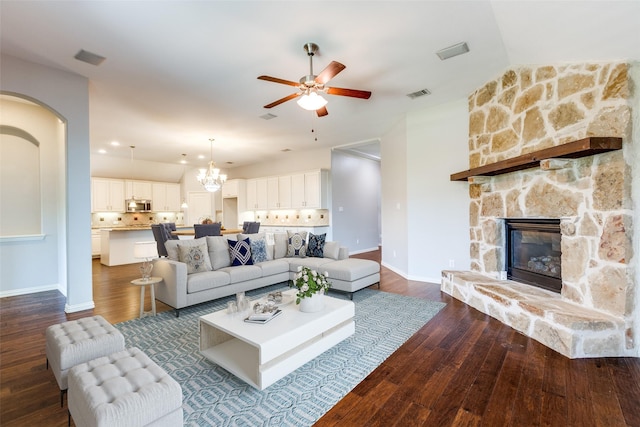 9728 Bitterroot Dr, Little Elm, TX 75068 - living area with a ceiling fan, dark wood-style floors, a fireplace, arched walkways, and a chandelier