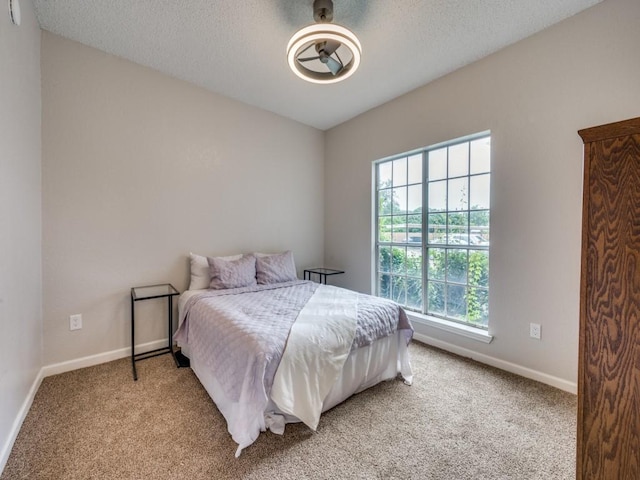 1603 Marsh Ln Unit 308, Carrollton, TX 75006 - bedroom with light carpet, baseboards, a textured ceiling, and ceiling fan