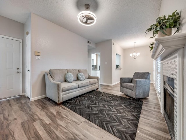 1603 Marsh Ln Unit 308, Carrollton, TX 75006 - living area with wood finished floors, a chandelier, a textured ceiling, and baseboards