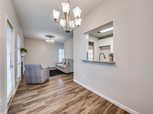 1603 Marsh Ln Unit 308, Carrollton, TX 75006 - living area with wood finished floors, baseboards, and a chandelier