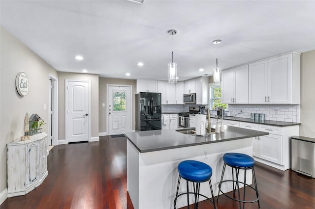 1105 Florence St, Mckinney, TX 75069 - kitchen featuring appliances with stainless steel finishes, dark countertops, dark wood finished floors, backsplash, and recessed lighting