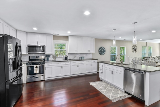 1105 Florence St, Mckinney, TX 75069 - kitchen featuring appliances with stainless steel finishes, a sink, dark countertops, tasteful backsplash, and dark wood-style floors