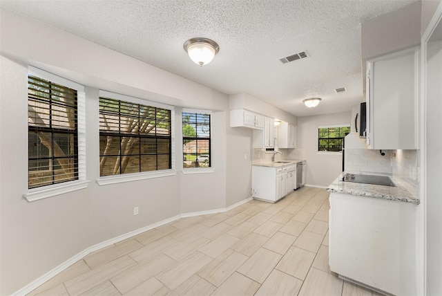 5008 Hatherly Dr, Plano, TX 75023 - kitchen featuring appliances with stainless steel finishes, baseboards, tasteful backsplash, a textured ceiling, and white cabinets