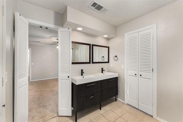5008 Hatherly Dr, Plano, TX 75023 - full bathroom with a closet, double vanity, a textured ceiling, ceiling fan, and baseboards