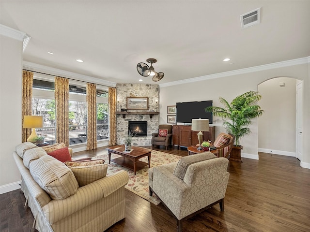 6420 Rosemary Ct, Mckinney, TX 75071 - living room featuring arched walkways, baseboards, ornamental molding, a fireplace, and dark wood-type flooring