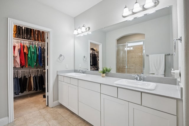 7717 Lake Worth Cv, Mckinney, TX 75071 - full bathroom with double vanity, a stall shower, a spacious closet, and tile patterned floors