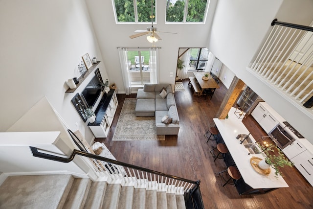 7717 Lake Worth Cv, Mckinney, TX 75071 - living room with a towering ceiling, wood finished floors, ceiling fan, and baseboards