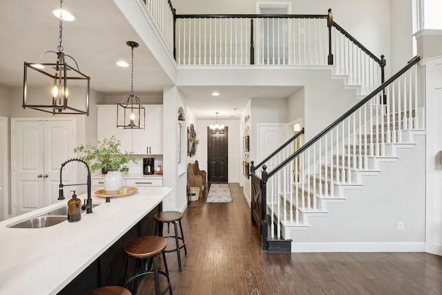 7717 Lake Worth Cv, Mckinney, TX 75071 - foyer entrance featuring a chandelier, a towering ceiling, dark wood-style flooring, stairs, and baseboards