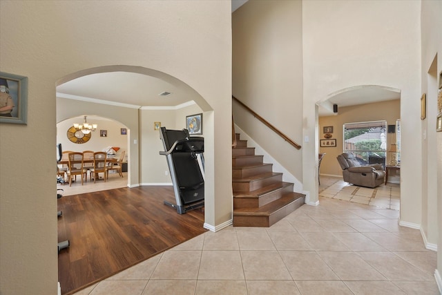 1230 Donegal Ln, Garland, TX 75044 - foyer entrance featuring arched walkways, light tile patterned floors, stairs, crown molding, and a high ceiling
