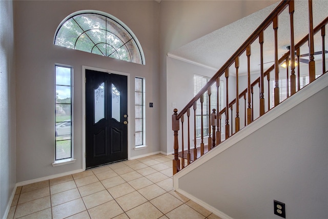 6613 Springmeadow Ln, Rowlett, TX 75089 - foyer entrance with healthy amount of natural light, baseboards, tile patterned floors, ornamental molding, and a towering ceiling