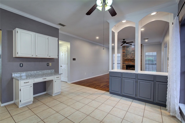 6613 Springmeadow Ln, Rowlett, TX 75089 - kitchen featuring ceiling fan, a fireplace, white cabinets, ornamental molding, and baseboards