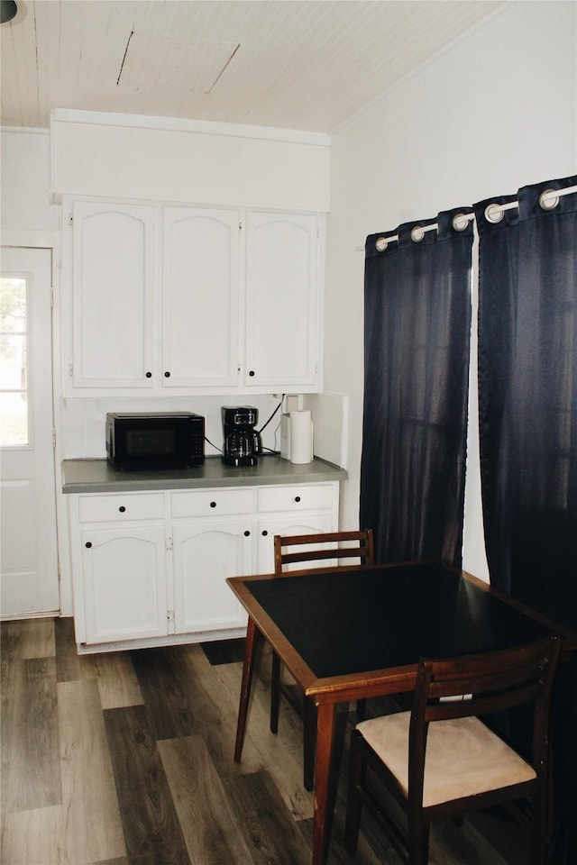 121 E E Ave B, Sanderson, TX 79848 - kitchen featuring black microwave, wood ceiling, dark wood-style floors, white cabinetry, and dark countertops
