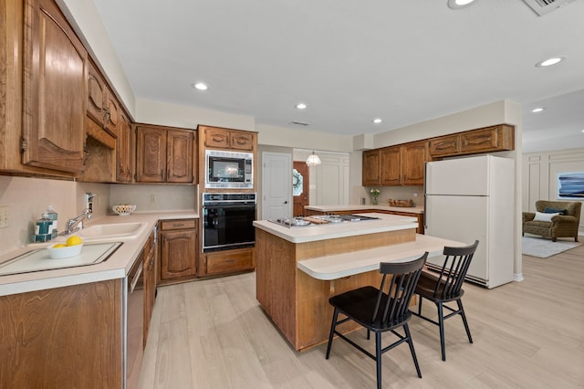 7213 Maranatha Ct, Colleyville, TX 76034 - kitchen featuring stainless steel appliances, a center island, light wood-type flooring, light countertops, and recessed lighting