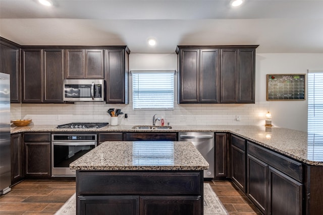 3822 Brazos St, Melissa, TX 75454 - kitchen featuring appliances with stainless steel finishes, a sink, dark brown cabinets, decorative backsplash, and recessed lighting