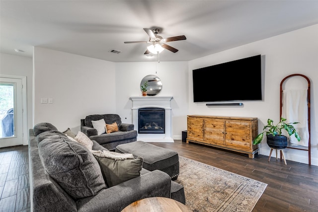 3822 Brazos St, Melissa, TX 75454 - living room with a ceiling fan, dark wood-type flooring, a glass covered fireplace, and baseboards