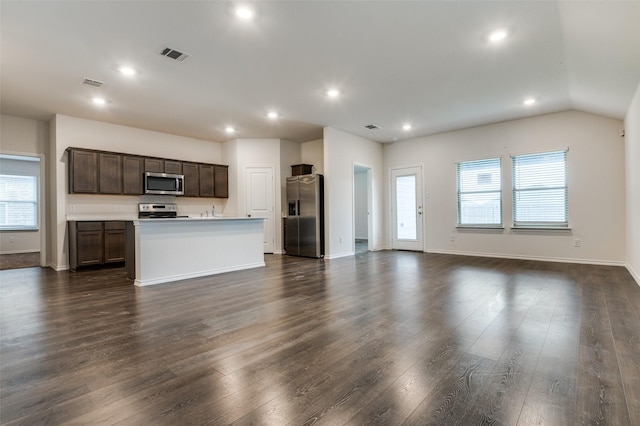 1937 Duskwood Dr, Lancaster, TX 75146 - kitchen with stainless steel appliances, open floor plan, dark brown cabinets, recessed lighting, and a kitchen island with sink