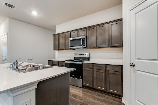 1937 Duskwood Dr, Lancaster, TX 75146 - kitchen featuring stainless steel appliances, dark wood-style floors, dark brown cabinetry, and light countertops