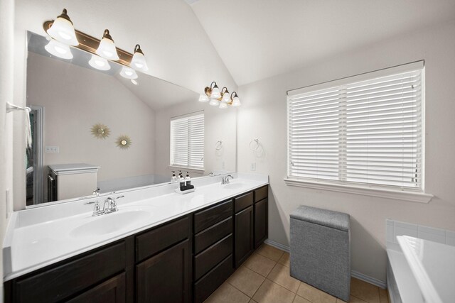 334 Hawthorn Dr, Fate, TX 75087 - full bath with vaulted ceiling, double vanity, a bath, tile patterned floors, and baseboards