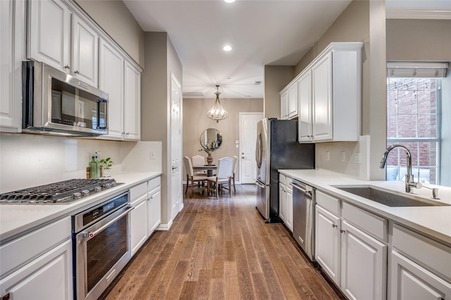 8250 Library St, Frisco, TX 75034 - kitchen with stainless steel appliances, a sink, wood finished floors, white cabinetry, and recessed lighting