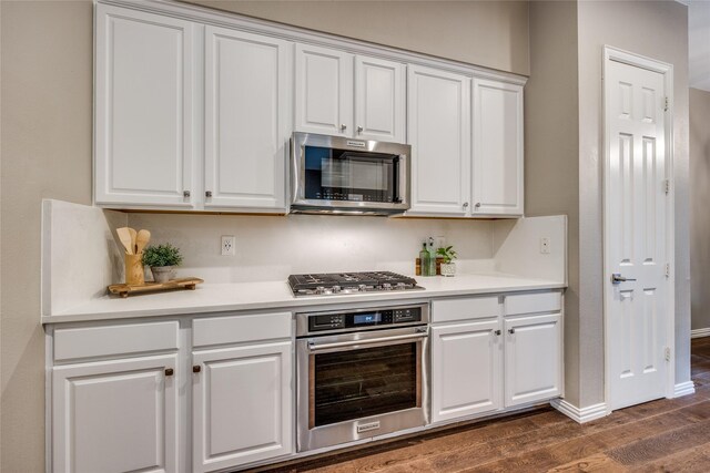 8250 Library St, Frisco, TX 75034 - kitchen with stainless steel appliances, white cabinetry, dark wood finished floors, light countertops, and baseboards