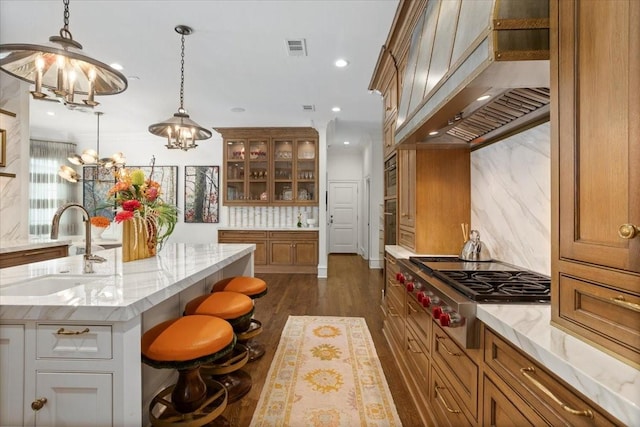 1128 Shady Oaks Ln, Westover Hills, TX 76107 - kitchen featuring a sink, extractor fan, stainless steel gas cooktop, brown cabinets, and glass insert cabinets