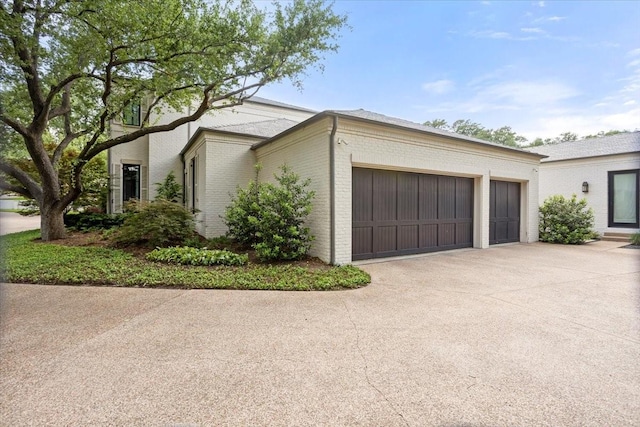 1128 Shady Oaks Ln, Westover Hills, TX 76107 - view of home's exterior featuring brick siding, an attached garage, and concrete driveway