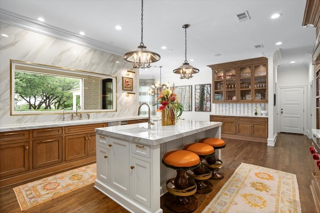 1128 Shady Oaks Ln, Westover Hills, TX 76107 - kitchen featuring a sink, brown cabinets, glass insert cabinets, a kitchen island with sink, and recessed lighting
