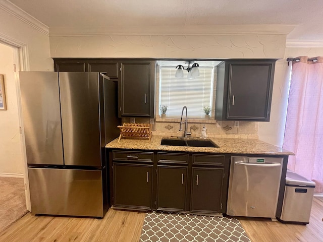 2605 Twinpost Ct, Irving, TX 75062 - kitchen featuring stainless steel appliances, ornamental molding, a sink, light wood-style flooring, and light stone counters