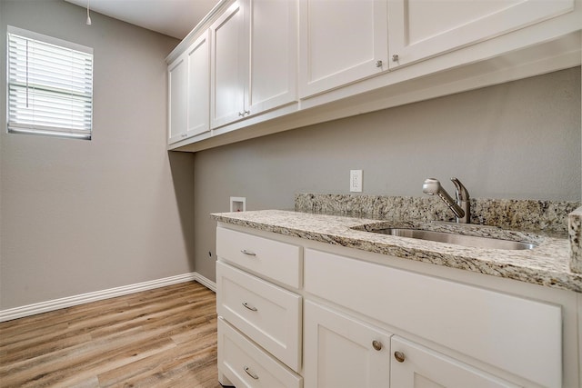 430 Mitchell Blvd, Weatherford, TX 76087 - laundry area with washer hookup, baseboards, cabinet space, and light wood-style floors