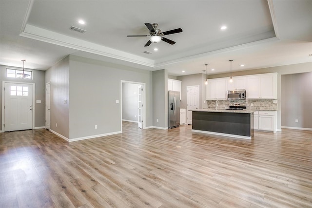 430 Mitchell Blvd, Weatherford, TX 76087 - unfurnished living room featuring a tray ceiling, recessed lighting, light wood-type flooring, a ceiling fan, and a sink