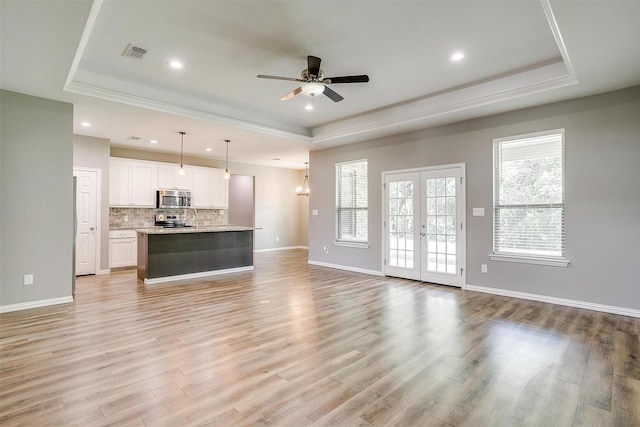 430 Mitchell Blvd, Weatherford, TX 76087 - unfurnished living room with a raised ceiling, a ceiling fan, baseboards, light wood-type flooring, and recessed lighting