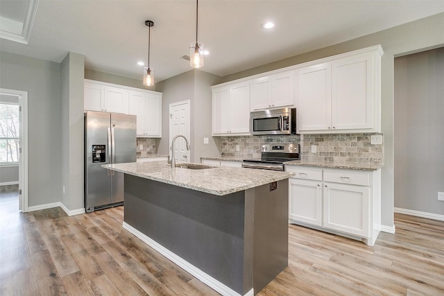 430 Mitchell Blvd, Weatherford, TX 76087 - kitchen featuring appliances with stainless steel finishes, a sink, backsplash, light wood finished floors, and recessed lighting