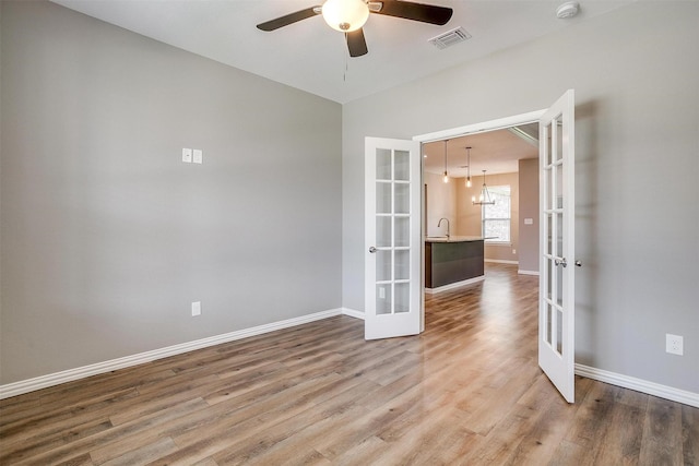 430 Mitchell Blvd, Weatherford, TX 76087 - empty room with french doors, wood finished floors, baseboards, and ceiling fan