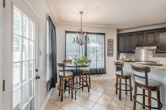 2508 Springhill Dr, Grapevine, TX 76051 - dining room with baseboards, a chandelier, a textured ceiling, and light tile patterned floors