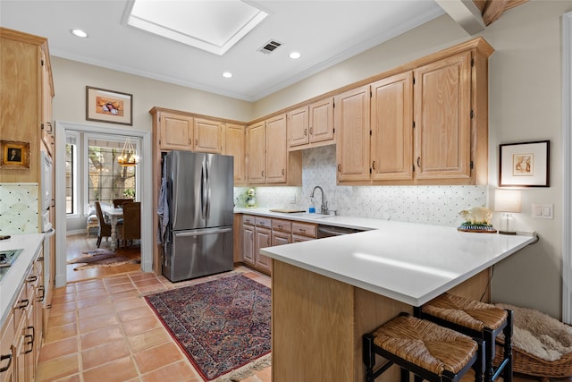 6518 Laurel Valley Rd, Dallas, TX 75248 - kitchen featuring freestanding refrigerator, light brown cabinets, a peninsula, light countertops, and tasteful backsplash