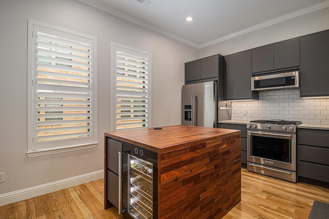 724 E Bluff St, Fort Worth, TX 76102 - kitchen featuring stainless steel appliances, butcher block countertops, ornamental molding, light wood-style floors, and wine cooler