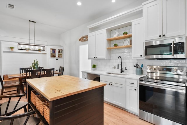 2415 Vz County Road 2624, Wills Point, TX 75169 - kitchen with appliances with stainless steel finishes, open shelves, a sink, butcher block countertops, and white cabinetry