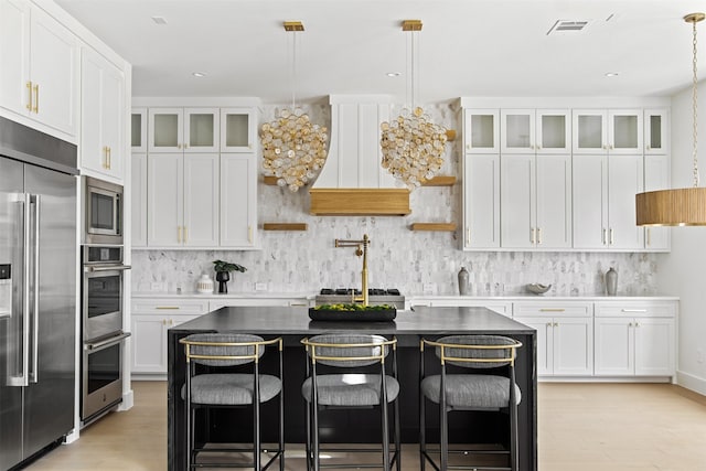 9974 Witham St, Dallas, TX 75220 - kitchen with appliances with stainless steel finishes, decorative backsplash, light wood-type flooring, and white cabinets