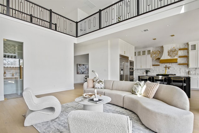 9974 Witham St, Dallas, TX 75220 - living area featuring light wood finished floors, a towering ceiling, and baseboards