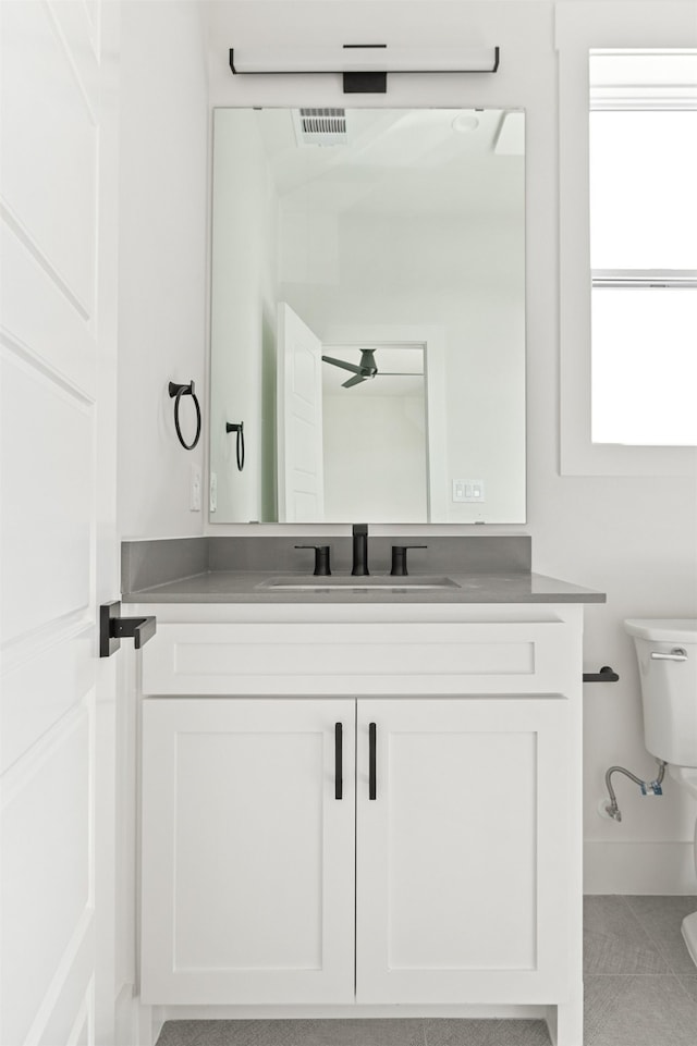 9974 Witham St, Dallas, TX 75220 - bathroom with toilet, vanity, ceiling fan, and tile patterned floors
