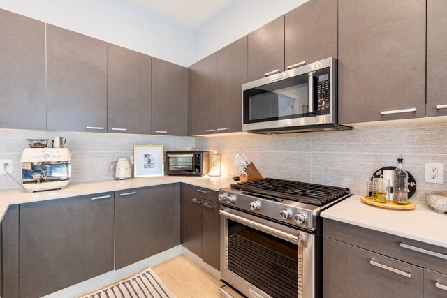4920 Zuma Ct, Dallas, TX 75206 - kitchen with appliances with stainless steel finishes, light countertops, backsplash, modern cabinets, and light wood finished floors