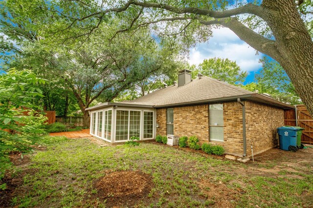 2212 Creekwood Ct, Flower Mound, TX 75028 - rear view of house with a sunroom, a chimney, brick siding, and a shingled roof