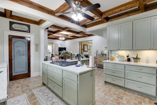 520 N College St, Waxahachie, TX 75165 - kitchen featuring stainless steel gas cooktop, ceiling fan, a kitchen island, coffered ceiling, and beamed ceiling